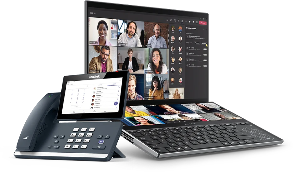 A Teams-certified desk phone beside a laptop running a Microsoft Teams video call